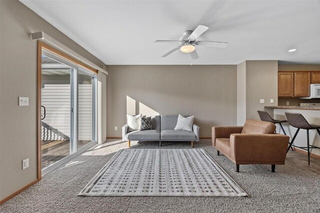 living room featuring ceiling fan and carpet