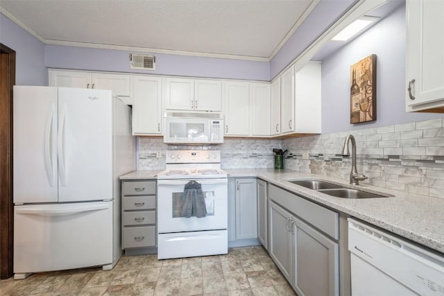 kitchen with white appliances, white cabinets, decorative backsplash, and sink