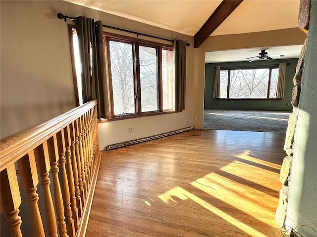 interior space featuring ceiling fan, vaulted ceiling with beams, and light hardwood / wood-style flooring