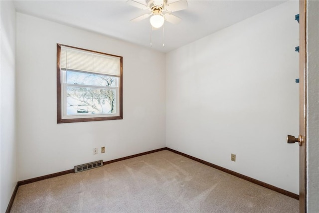 spare room with ceiling fan and light carpet