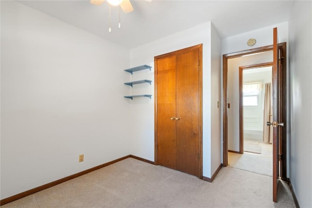 unfurnished bedroom with ceiling fan and light colored carpet