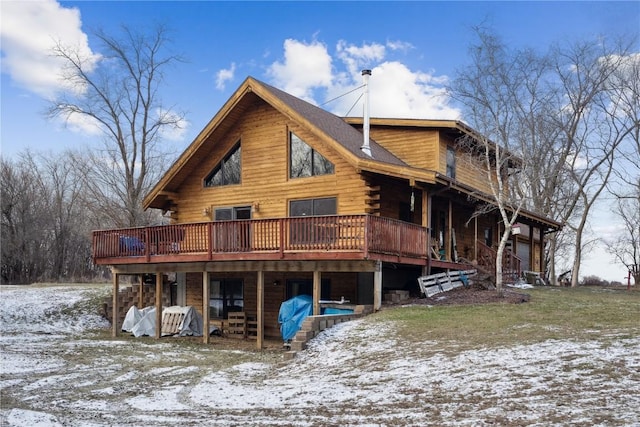 snow covered rear of property with a wooden deck