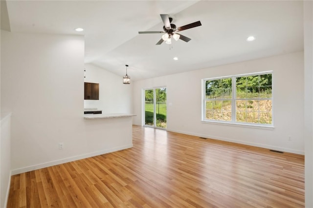 unfurnished living room featuring ceiling fan, light wood-type flooring, and vaulted ceiling