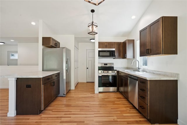 kitchen featuring appliances with stainless steel finishes, hanging light fixtures, sink, and dark brown cabinetry