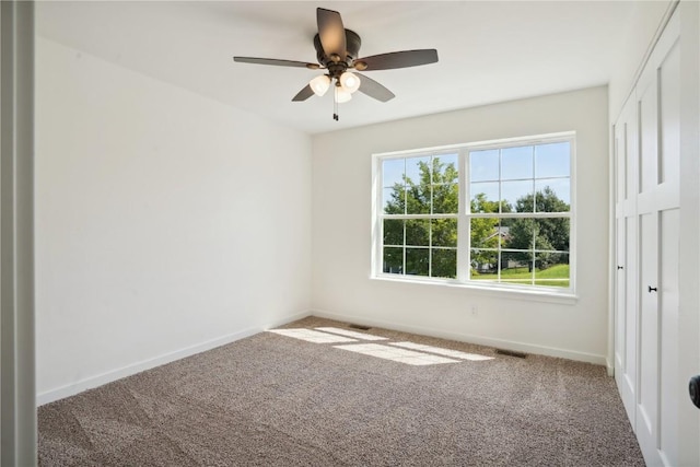 carpeted spare room with ceiling fan