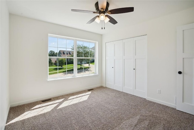 unfurnished bedroom with ceiling fan, a closet, and carpet