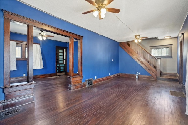 unfurnished living room with a textured ceiling and dark wood-type flooring