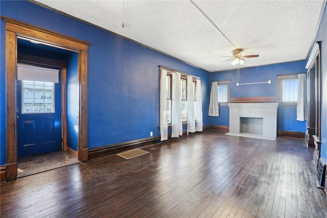 unfurnished living room featuring a textured ceiling, ceiling fan, and dark hardwood / wood-style floors