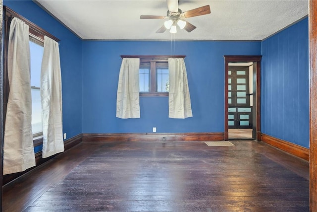 unfurnished room with ceiling fan, dark wood-type flooring, and a textured ceiling