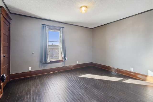 spare room with ornamental molding, dark wood-type flooring, and a textured ceiling