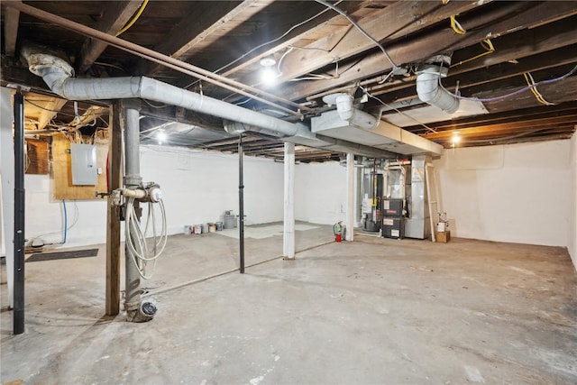 basement with electric panel, heating unit, and gas water heater