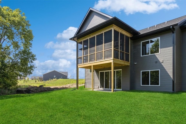 back of house with a yard and a sunroom