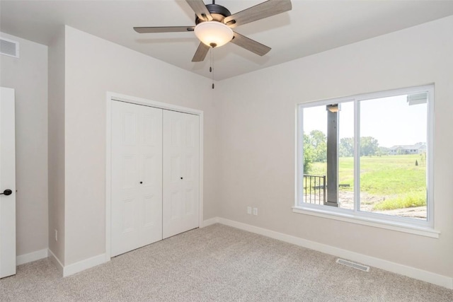 unfurnished bedroom featuring a closet, ceiling fan, and light colored carpet