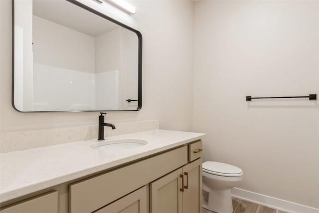 bathroom with toilet, a shower, vanity, and hardwood / wood-style flooring