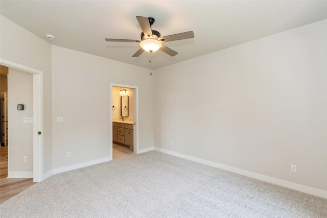 unfurnished bedroom featuring connected bathroom, ceiling fan, and light colored carpet