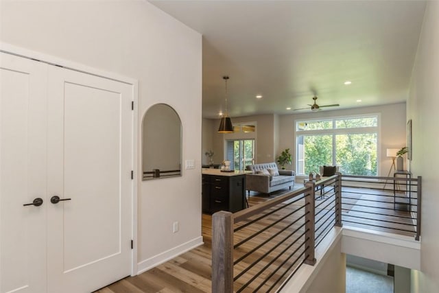 staircase with ceiling fan and hardwood / wood-style flooring