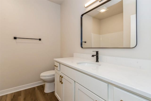 bathroom featuring toilet, wood-type flooring, and vanity