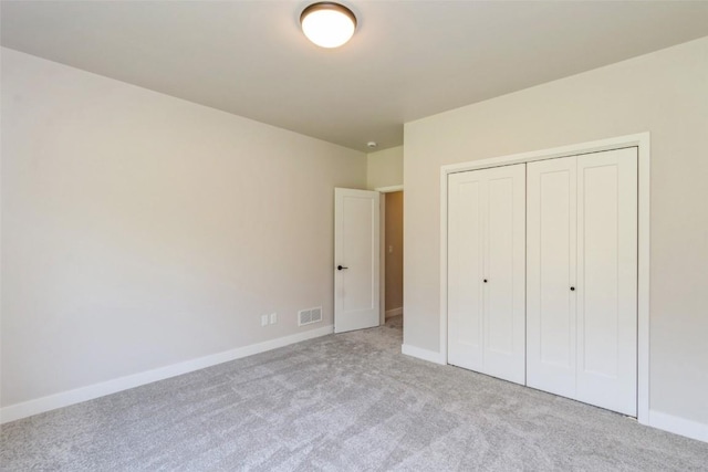 unfurnished bedroom featuring a closet and light carpet