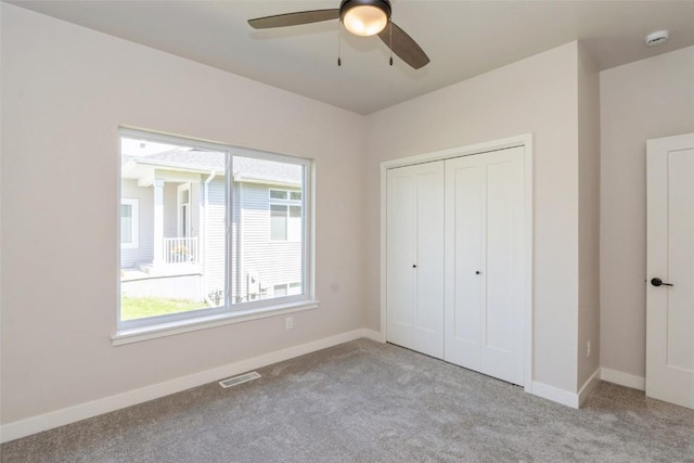 unfurnished bedroom featuring light carpet, a closet, and ceiling fan