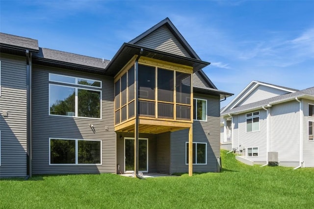 back of property featuring central AC unit, a lawn, and a sunroom