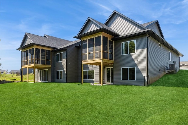 back of house featuring central AC, a sunroom, and a lawn