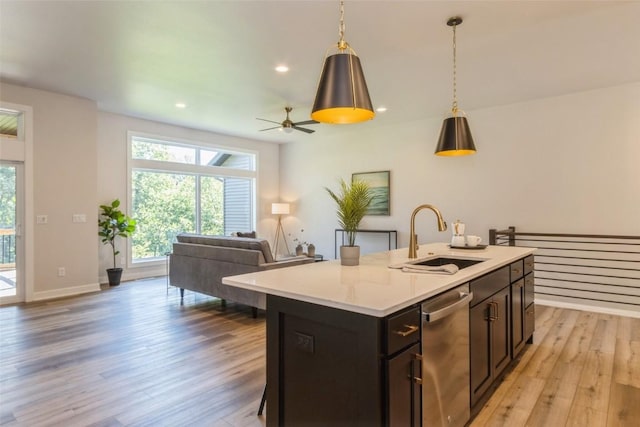 kitchen with a kitchen island with sink, ceiling fan, sink, light hardwood / wood-style flooring, and stainless steel dishwasher