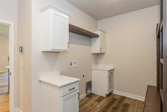 laundry room with electric dryer hookup, cabinets, dark hardwood / wood-style floors, and washer hookup