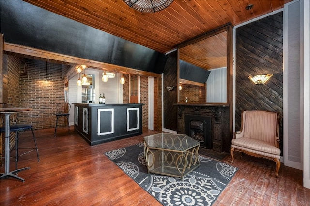 interior space with a large fireplace, brick wall, dark hardwood / wood-style flooring, and wooden ceiling