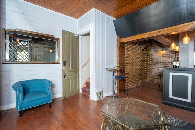 interior space with brick wall, wood walls, wooden ceiling, and dark hardwood / wood-style floors