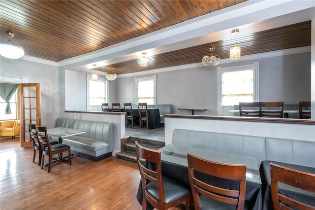 living room featuring hardwood / wood-style flooring, crown molding, wood ceiling, and breakfast area