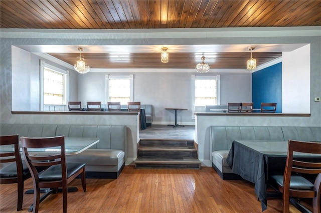 dining area featuring wood ceiling, crown molding, a healthy amount of sunlight, and hardwood / wood-style floors