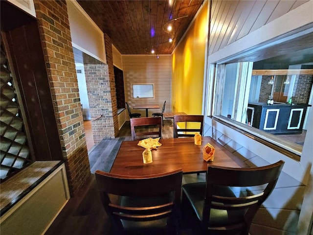 dining area with wooden ceiling and wood walls