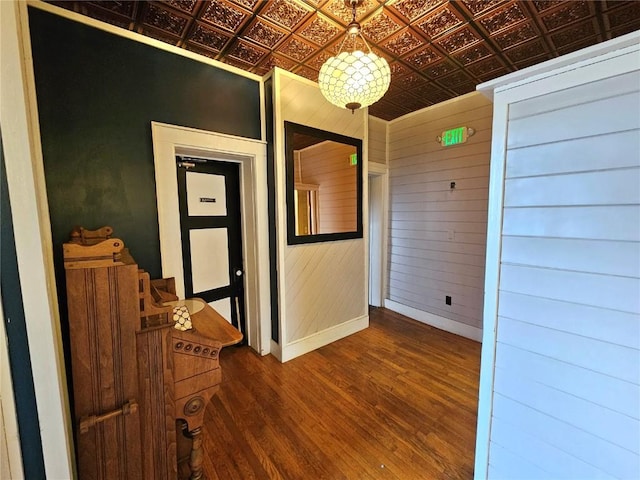 corridor featuring wood-type flooring and wood walls