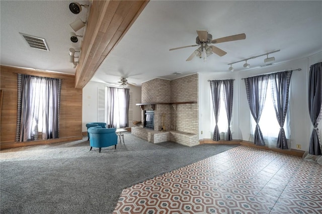 unfurnished living room featuring a fireplace, ceiling fan, and carpet flooring