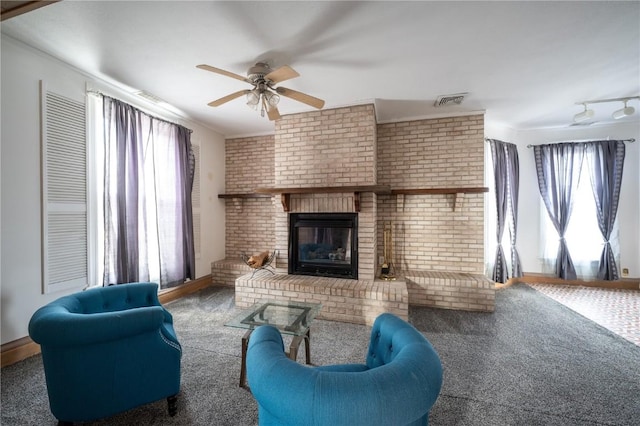 living room featuring a brick fireplace, ceiling fan, and carpet