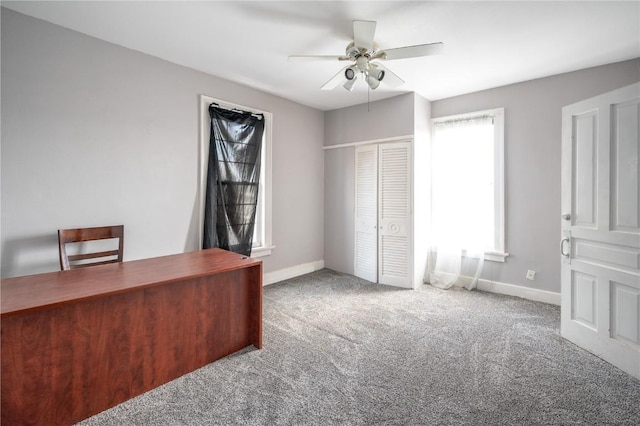 unfurnished office featuring ceiling fan and carpet