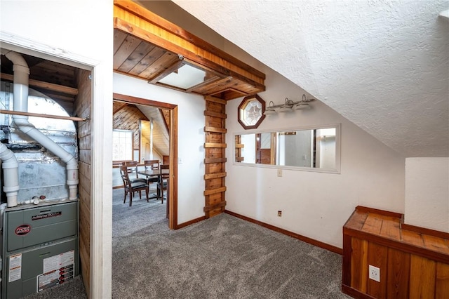 bonus room with a textured ceiling, lofted ceiling, and dark colored carpet