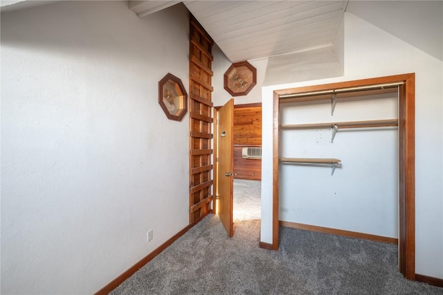 unfurnished bedroom with lofted ceiling, dark colored carpet, and a closet