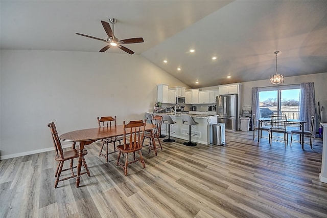 dining area with lofted ceiling, sink, ceiling fan, and light hardwood / wood-style flooring