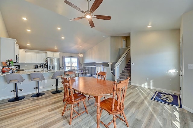 dining space featuring ceiling fan, vaulted ceiling, light hardwood / wood-style flooring, and sink