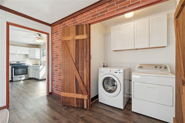 clothes washing area with ceiling fan, dark hardwood / wood-style floors, washing machine and clothes dryer, and brick wall