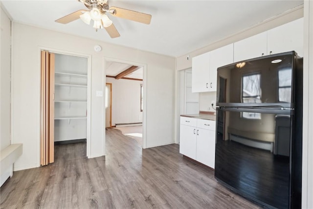 kitchen featuring black fridge, a baseboard radiator, white cabinetry, and light wood-type flooring