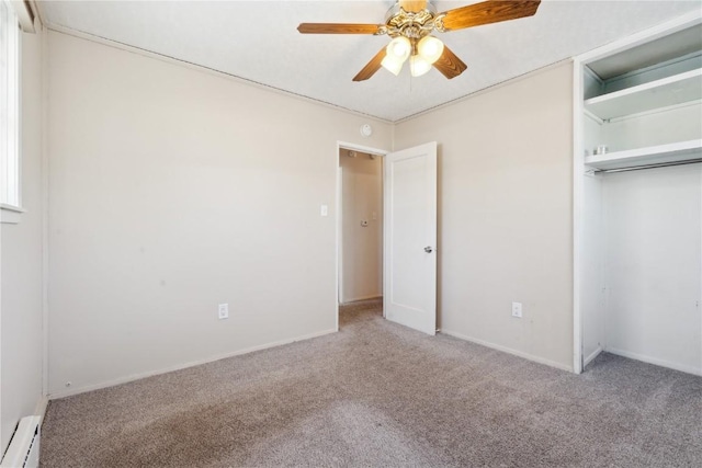 unfurnished bedroom featuring a closet, a baseboard heating unit, ceiling fan, and carpet floors