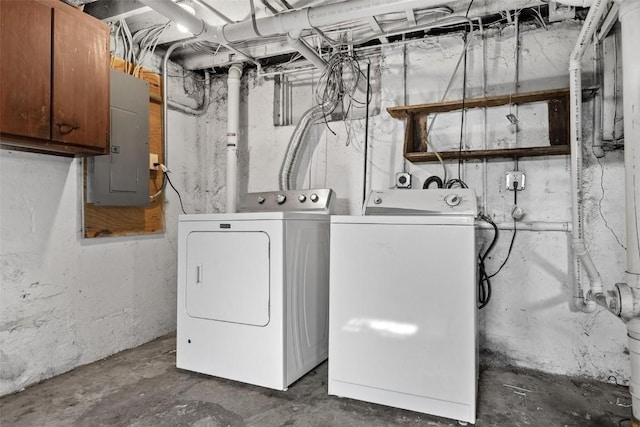 laundry area featuring washer and dryer, electric panel, and cabinets