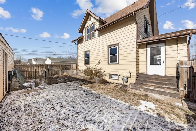 view of snow covered rear of property