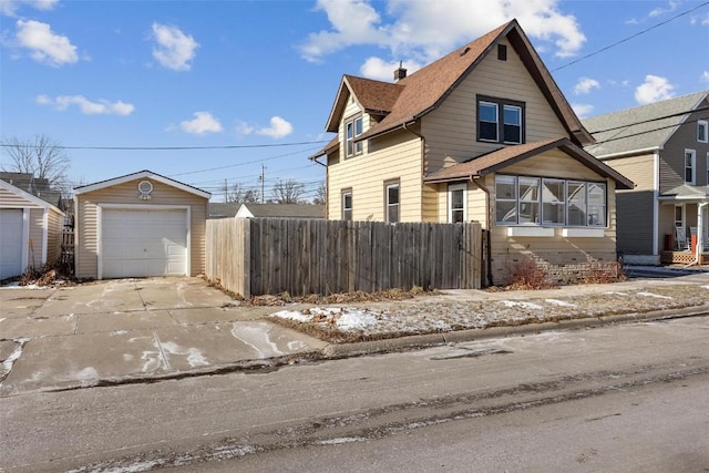 view of front of home featuring a garage and an outbuilding