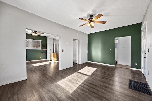 unfurnished living room featuring ceiling fan and dark hardwood / wood-style floors