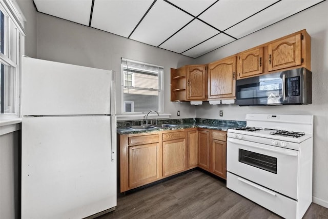 kitchen with white appliances, dark wood-type flooring, and sink