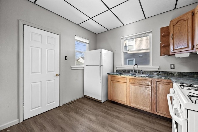 kitchen featuring white appliances, dark hardwood / wood-style flooring, a paneled ceiling, and sink