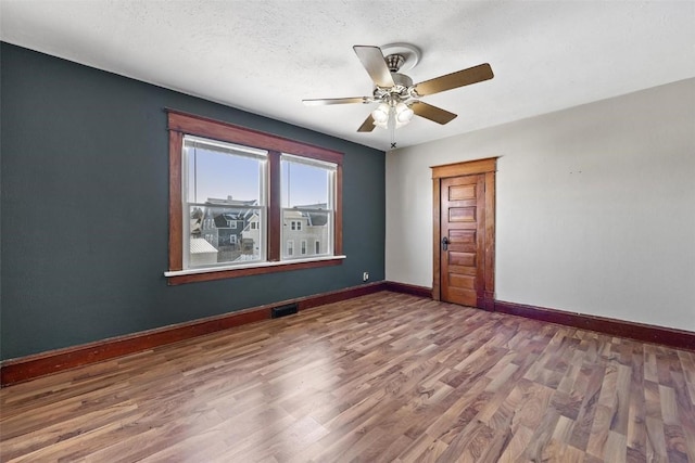 spare room featuring a textured ceiling, ceiling fan, and hardwood / wood-style flooring